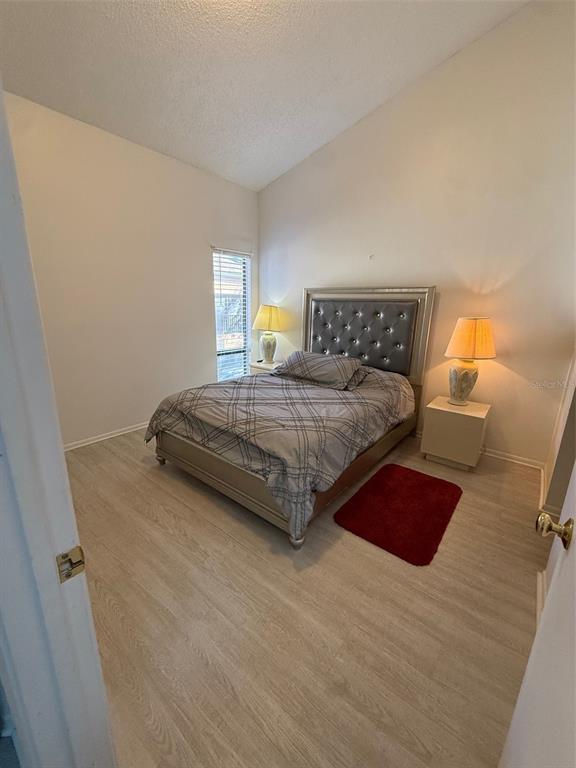 6206 Raintree Drive, Unit GE Orlando, FL 32822 - Photo 8 of 18 a bedroom with a bed and wooden floor