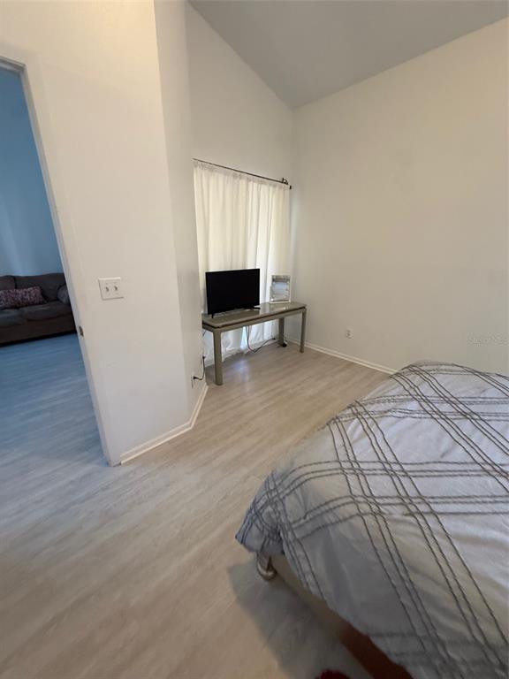 6206 Raintree Drive, Unit GE Orlando, FL 32822 - Photo 9 of 18 a bedroom with a bed and a television