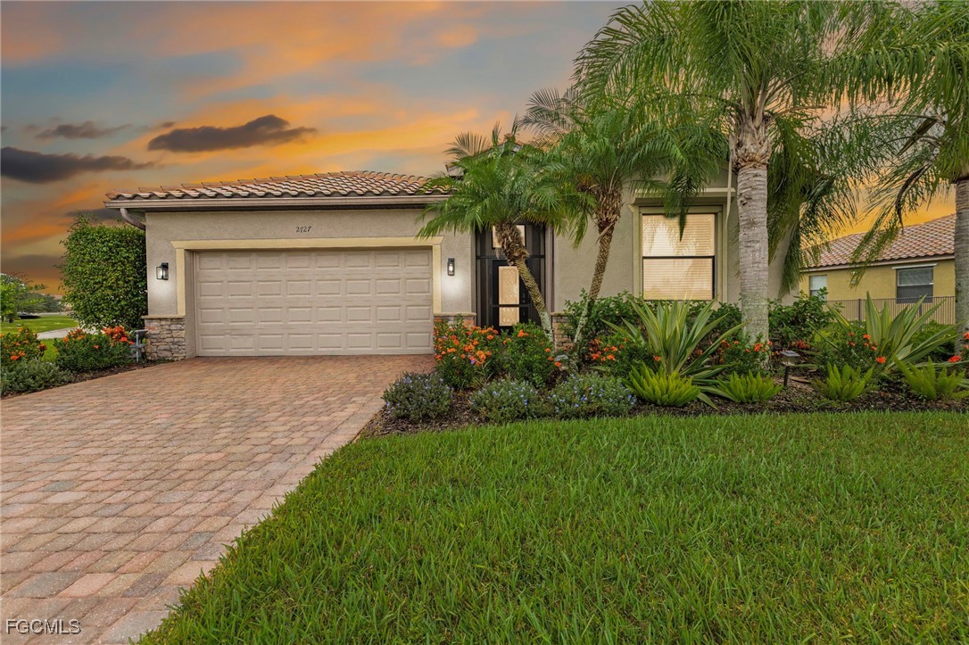 2727 Via Piazza Loop Fort Myers, FL 33905 - Photo 1 of 35 a front view of a house with a garden and palm trees