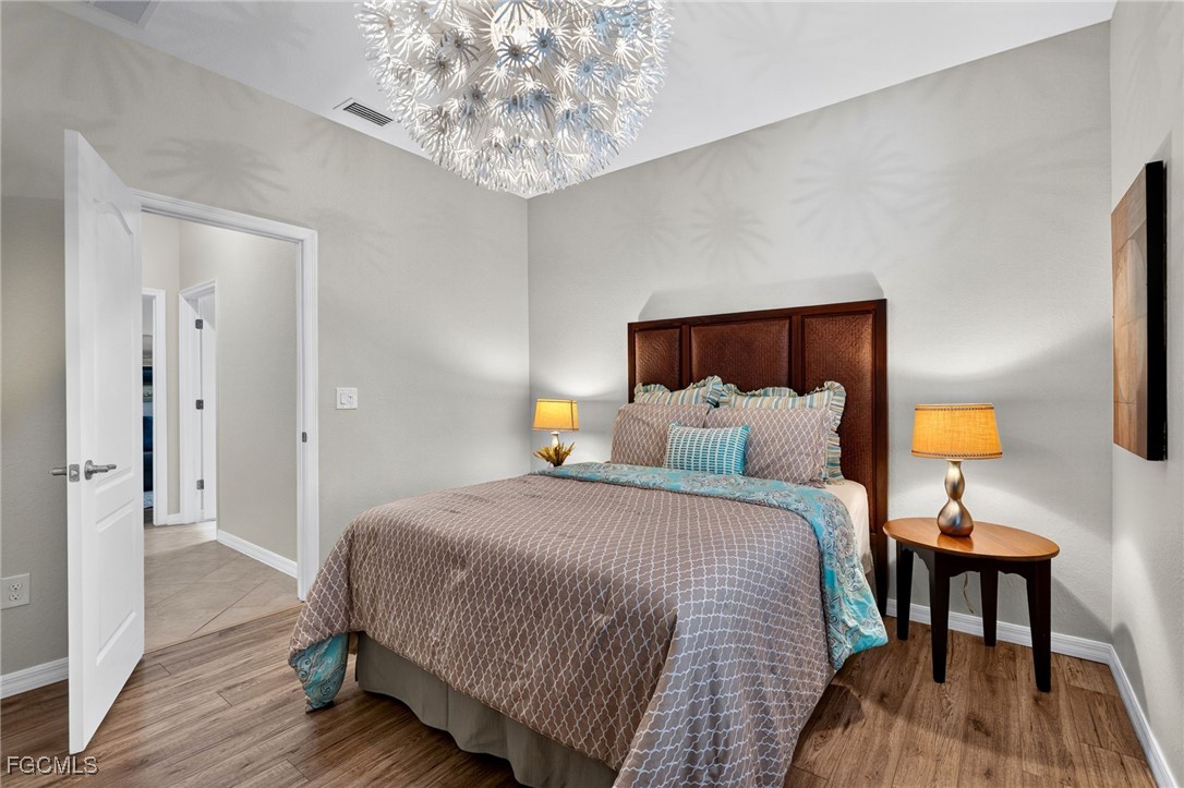 2727 Via Piazza Loop Fort Myers, FL 33905 - Photo 22 of 35 a bedroom with a bed and wooden floor