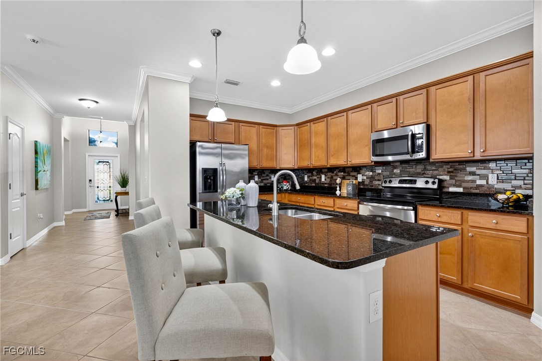 2727 Via Piazza Loop Fort Myers, FL 33905 - Photo 6 of 35 a kitchen with stainless steel appliances granite countertop a stove top oven a sink dishwasher a dining table and chairs with wooden floor