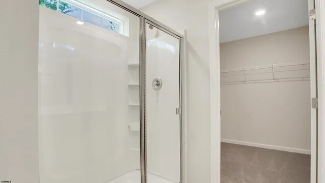 a bathroom with a glass shower door and a shower
