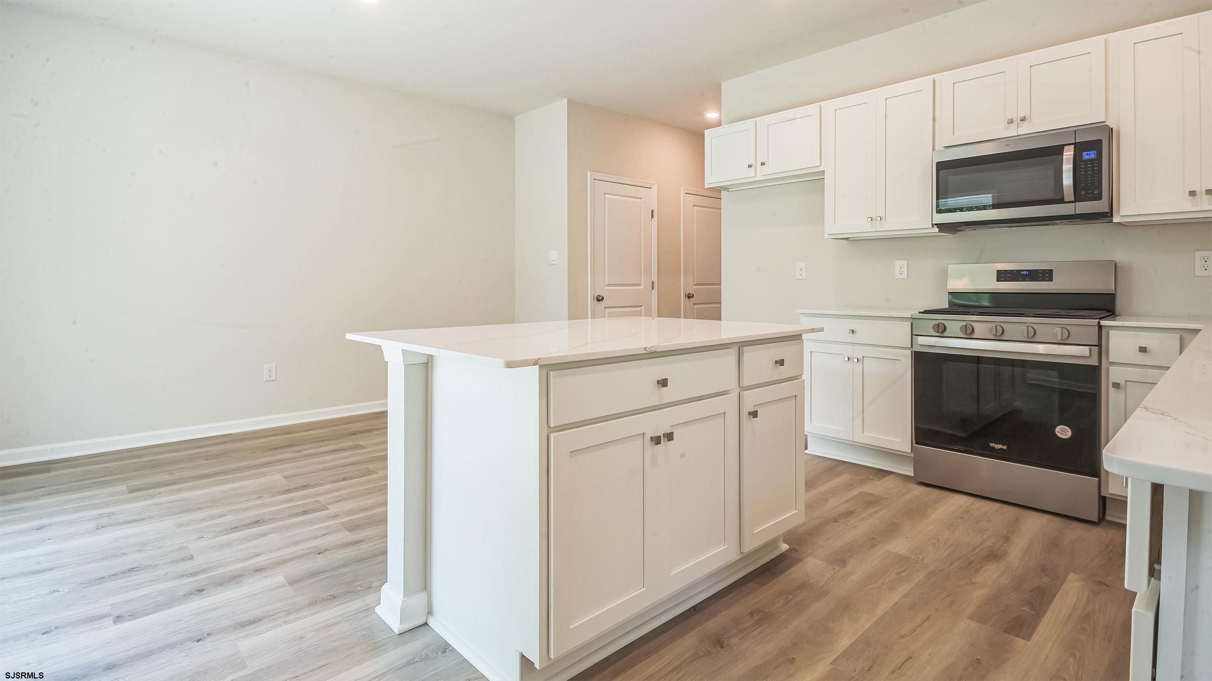7 Emilie Court Richland, NJ 08350 - Photo 4 of 23 a kitchen with stainless steel appliances granite countertop a stove top oven a sink and white cabinets