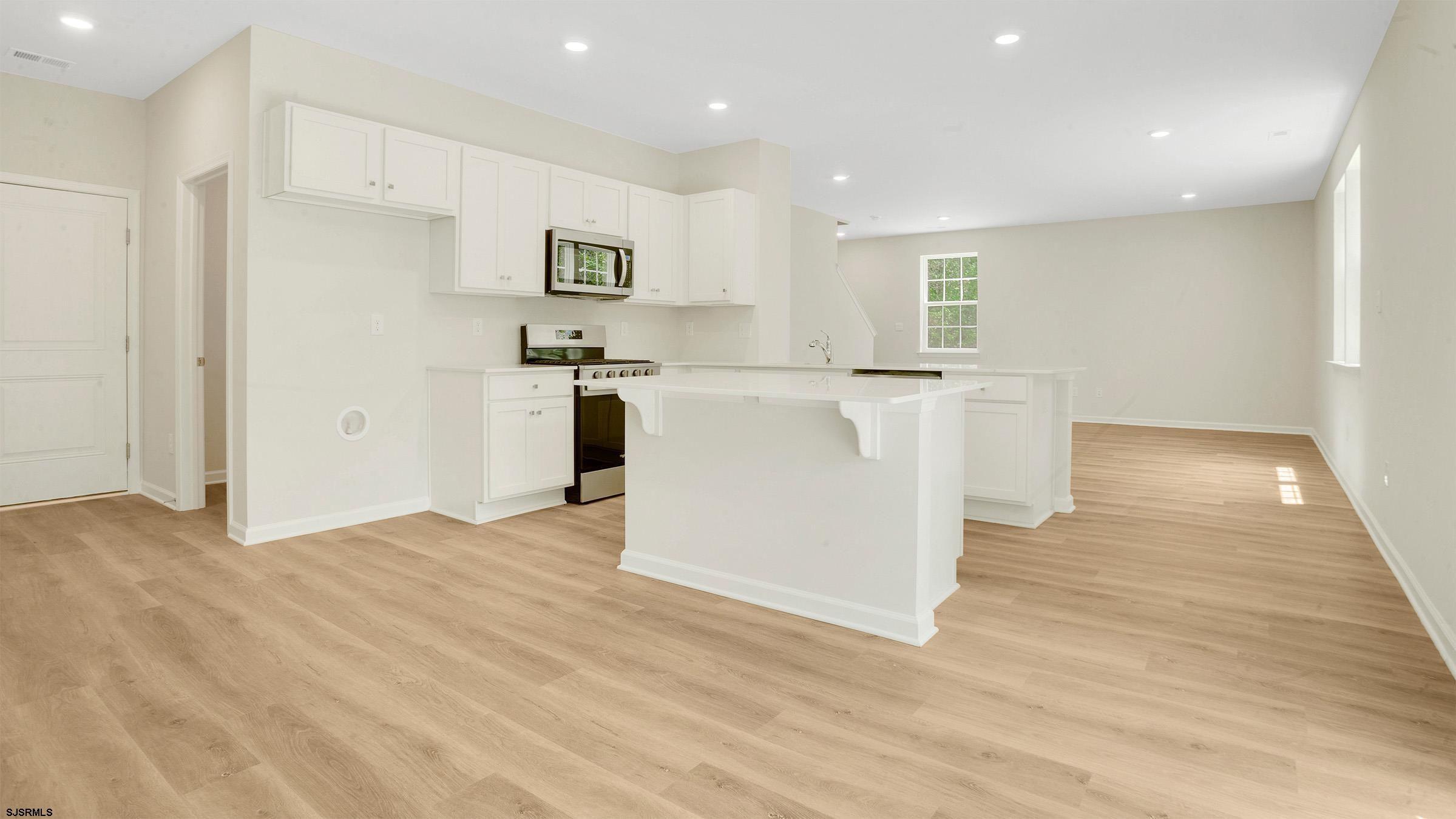 7 Emilie Court Richland, NJ 08350 - Photo 7 of 23 a kitchen with stainless steel appliances white cabinets and wooden floor