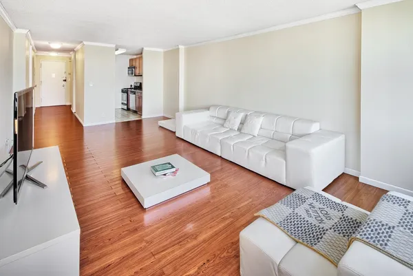 a living room with furniture and a wooden floor