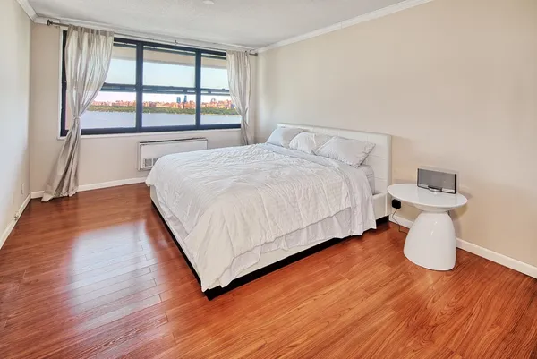 a bedroom with a bed and wooden floor