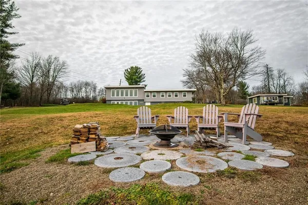 a view of a lake with chairs and table on the patio