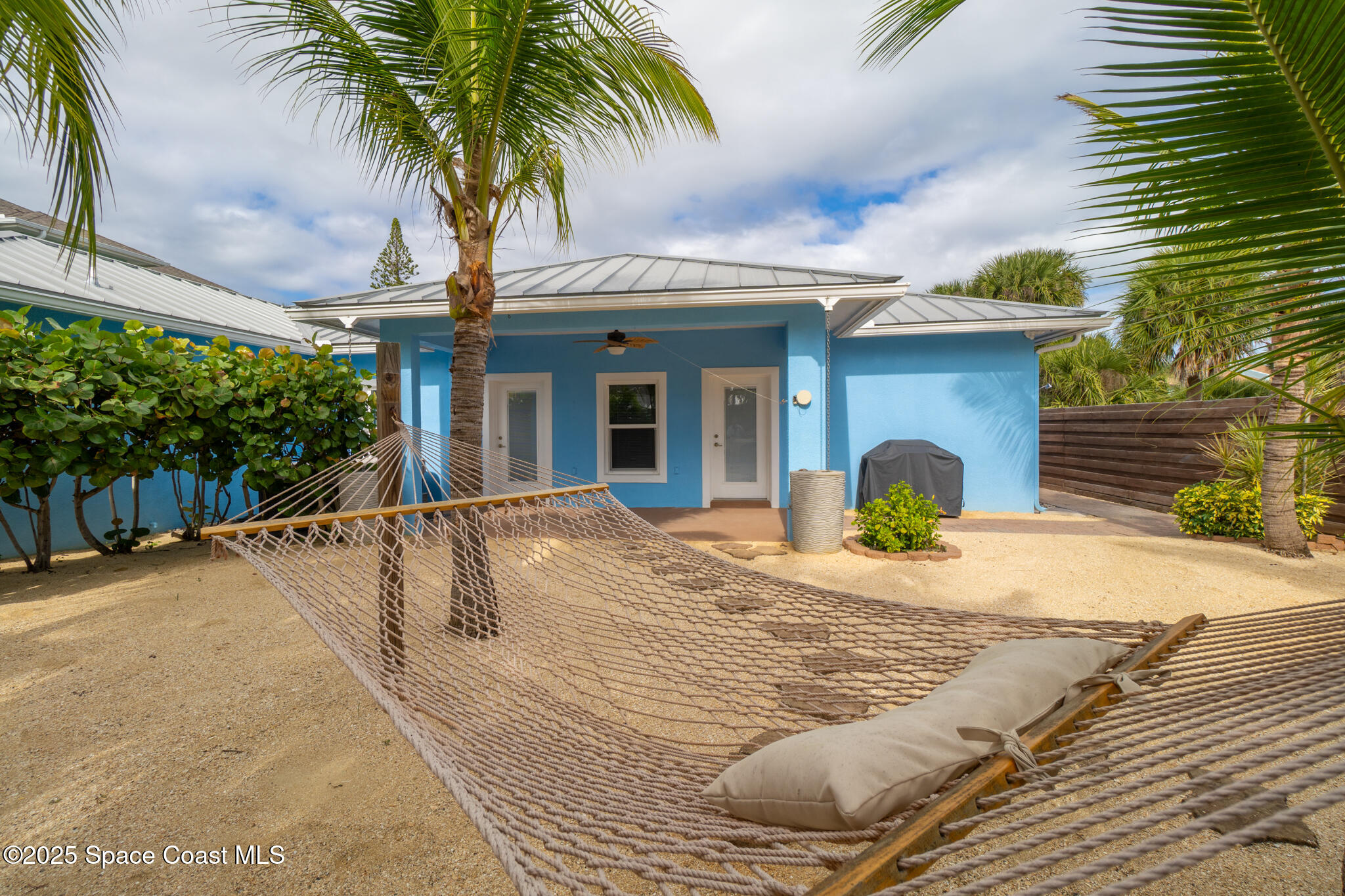 131 Harding Avenue, Unit 131 & 129 Cocoa Beach, FL 32931 - Photo 21 of 47 a view of yellow house with palm trees