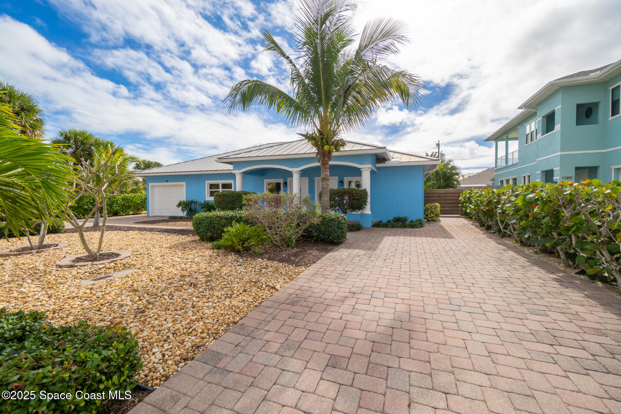 131 Harding Avenue, Unit 131 & 129 Cocoa Beach, FL 32931 - Photo 23 of 47 a front view of a house with a garden