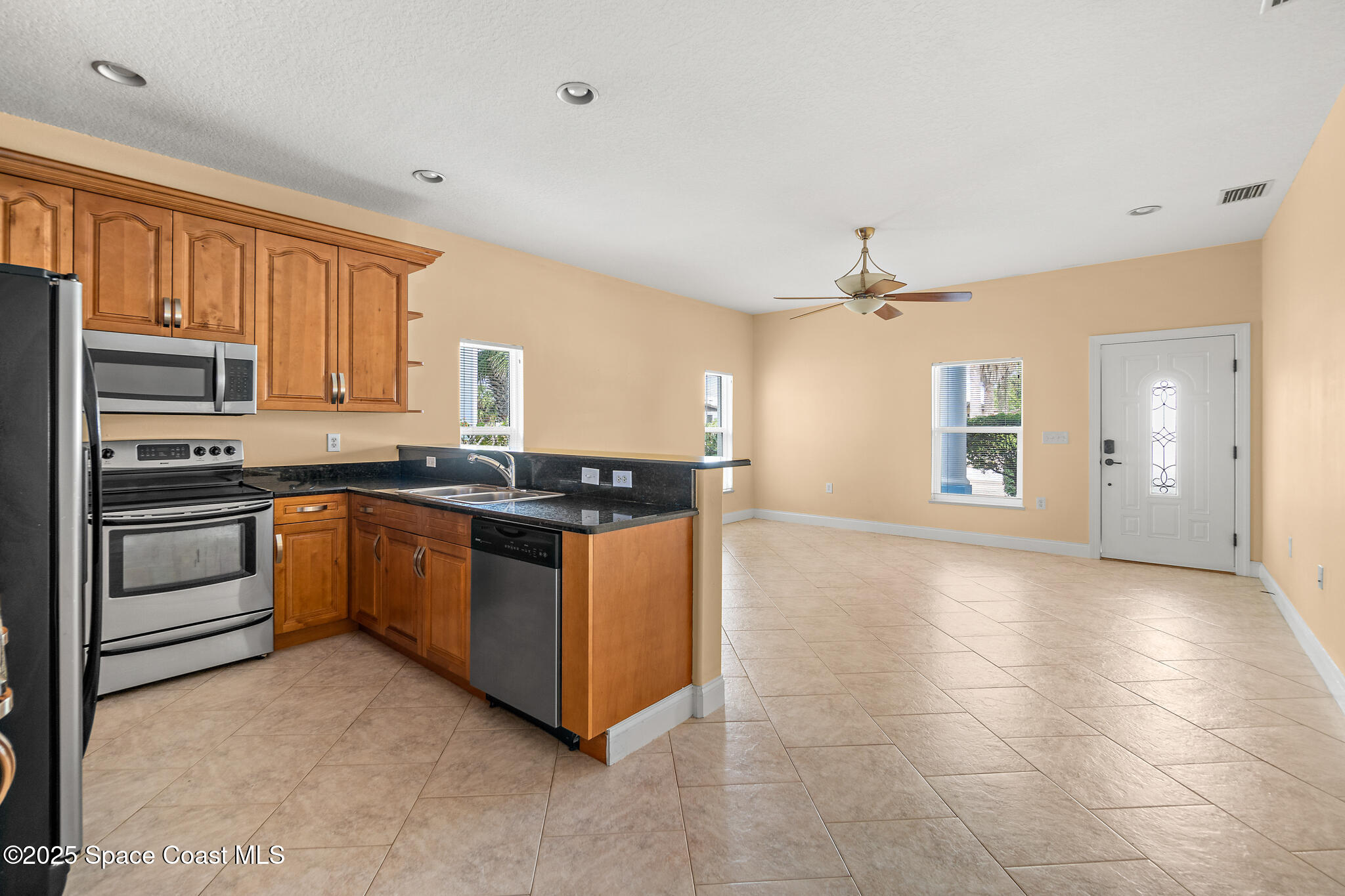 131 Harding Avenue, Unit 131 & 129 Cocoa Beach, FL 32931 - Photo 24 of 47 a kitchen with granite countertop a stove cabinets and a refrigerator