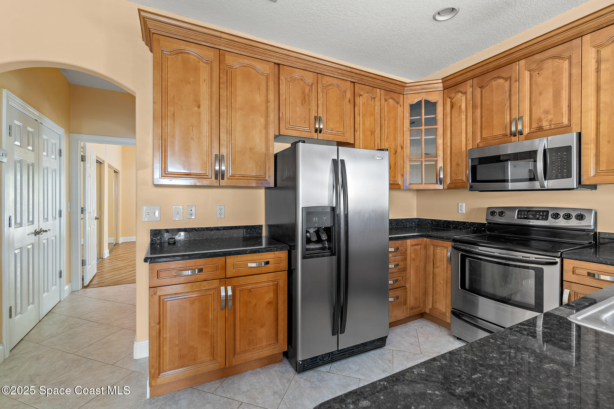 131 Harding Avenue, Unit 131 & 129 Cocoa Beach, FL 32931 - Photo 25 of 47 a kitchen with stainless steel appliances granite countertop a refrigerator stove and microwave