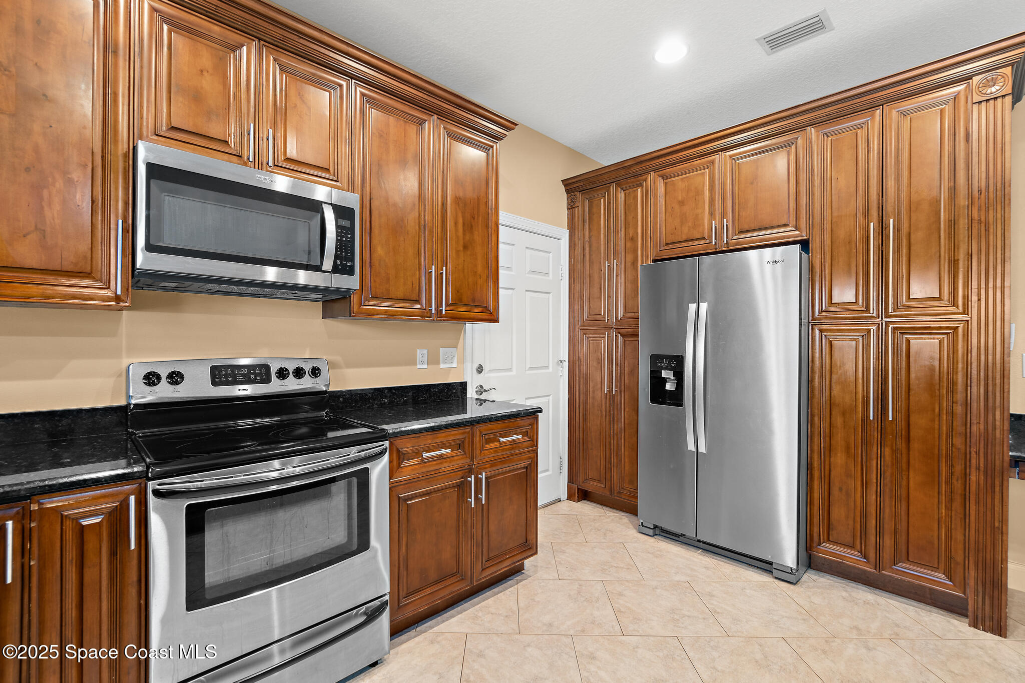 131 Harding Avenue, Unit 131 & 129 Cocoa Beach, FL 32931 - Photo 3 of 47 a kitchen with stainless steel appliances granite countertop a refrigerator stove and microwave