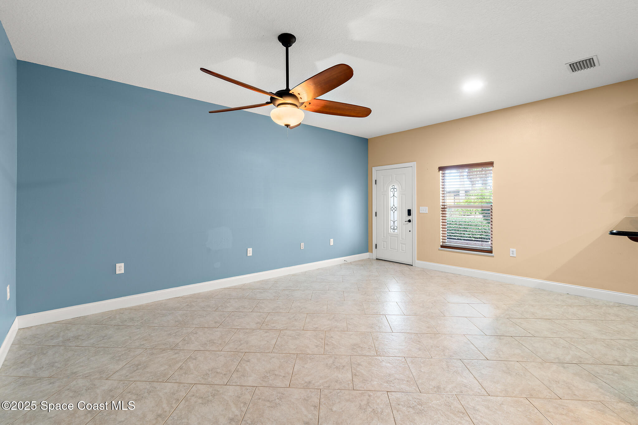 131 Harding Avenue, Unit 131 & 129 Cocoa Beach, FL 32931 - Photo 7 of 47 an empty room with windows and fan