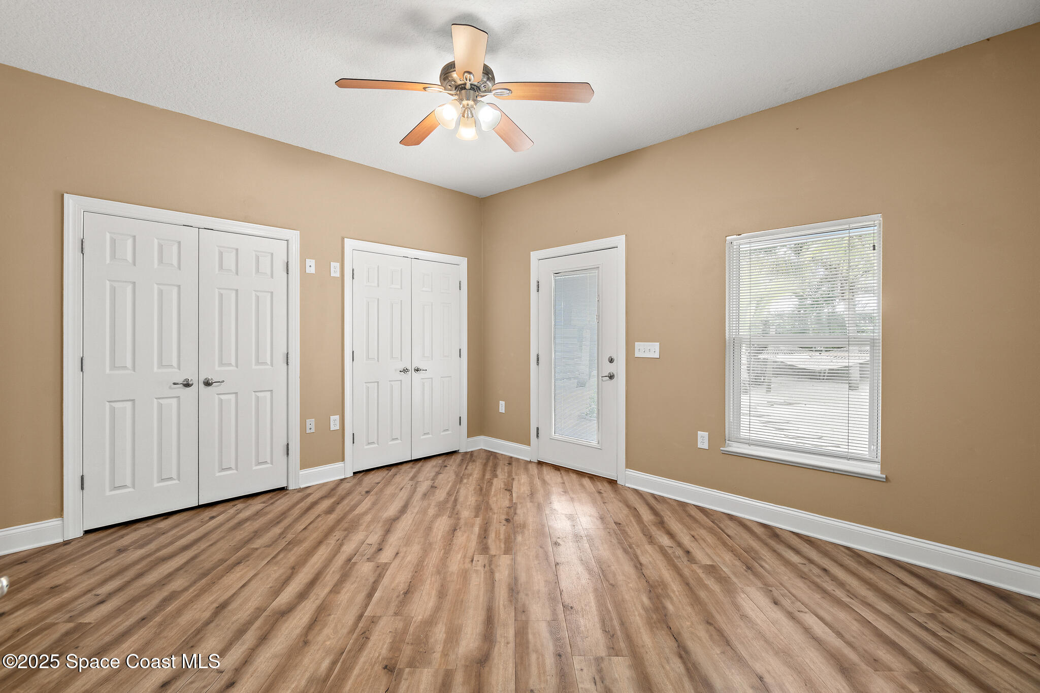 131 Harding Avenue, Unit 131 & 129 Cocoa Beach, FL 32931 - Photo 10 of 47 a view of an empty room with a window and wooden floor
