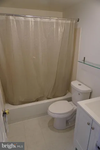 a white toilet sitting next to a shower