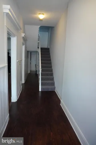 a view of a hallway with wooden floor and stairs