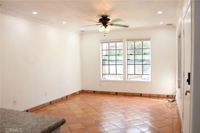 an empty room with a ceiling fan and window