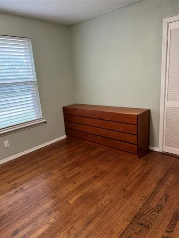a room with a wooden floor and a window