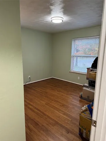 a room with wooden floor and gym equipment