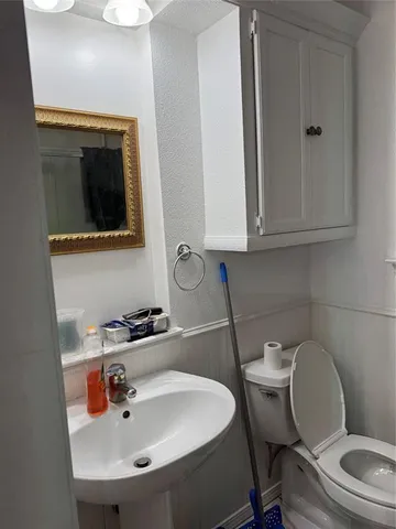 a bathroom with a toilet a sink and mirror