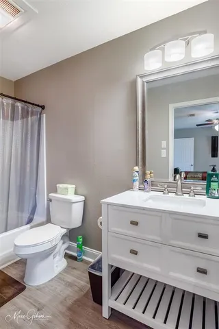 a bathroom with a sink mirror and toilet