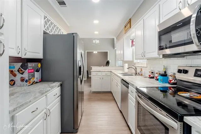 a kitchen with a sink a stove and cabinets