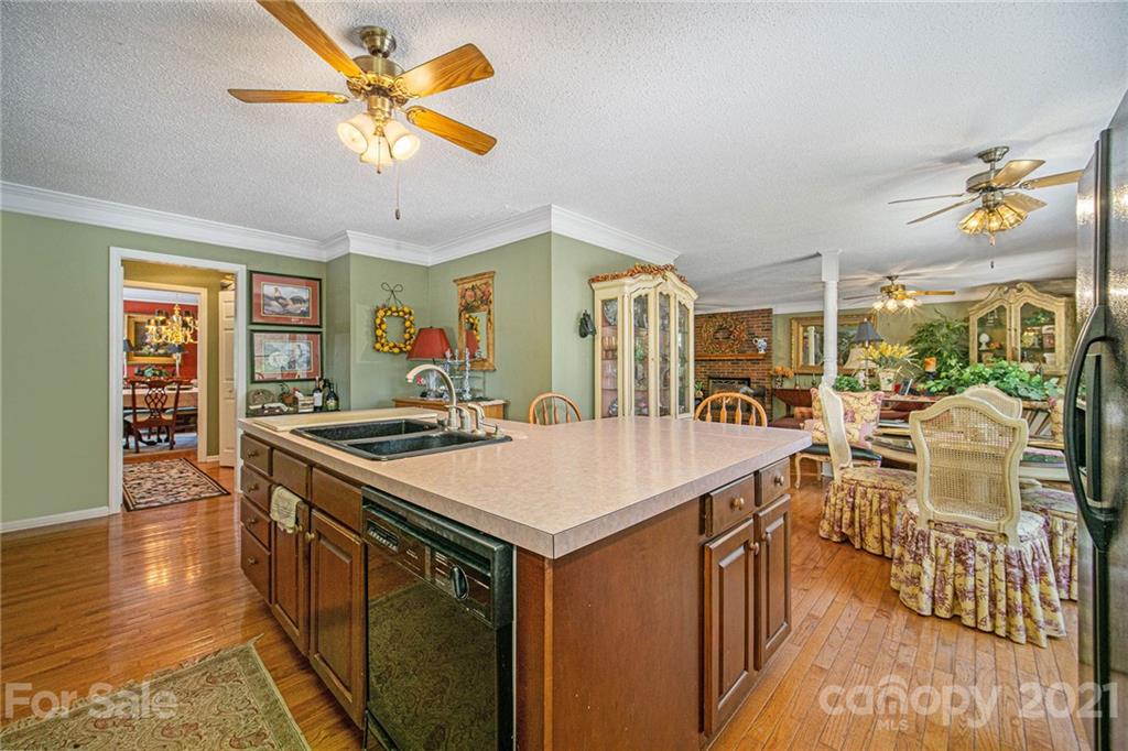 485 Mt Tabor Road Cleveland, NC 27013 - Photo 16 of 28 a view of a kitchen with kitchen island a stove a sink a dining table and chairs with wooden floor