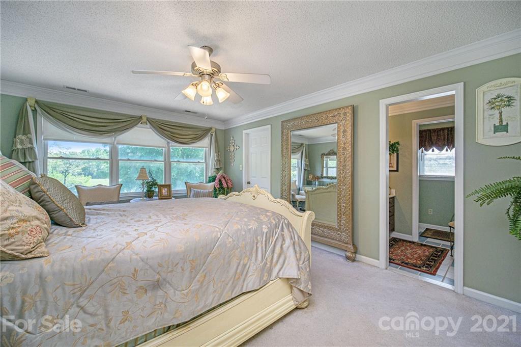 485 Mt Tabor Road Cleveland, NC 27013 - Photo 19 of 28 a bedroom with a large bed and a chandelier