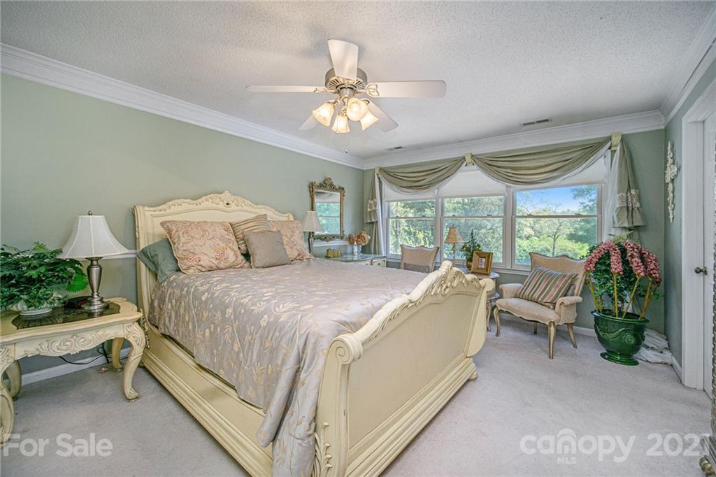 485 Mt Tabor Road Cleveland, NC 27013 - Photo 20 of 28 a spacious bedroom with a bed and a chandelier