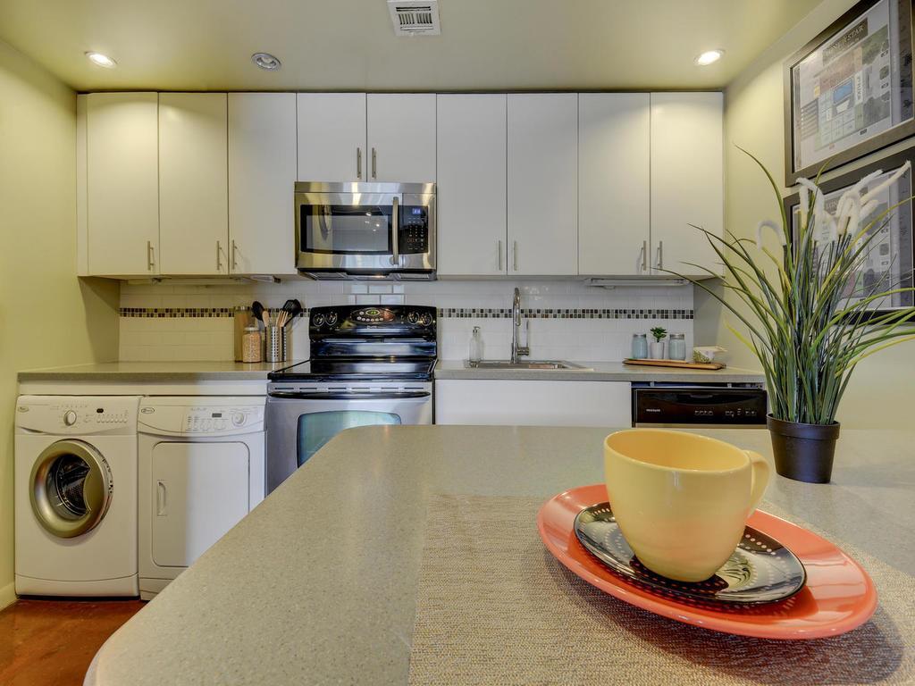 2408 Leon Street, Unit 302 Austin, TX 78705 - Photo 4 of 6 a kitchen with a stove a sink and a cabinets