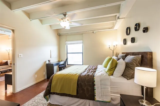 a bedroom with a bed and a lamp on the dresser