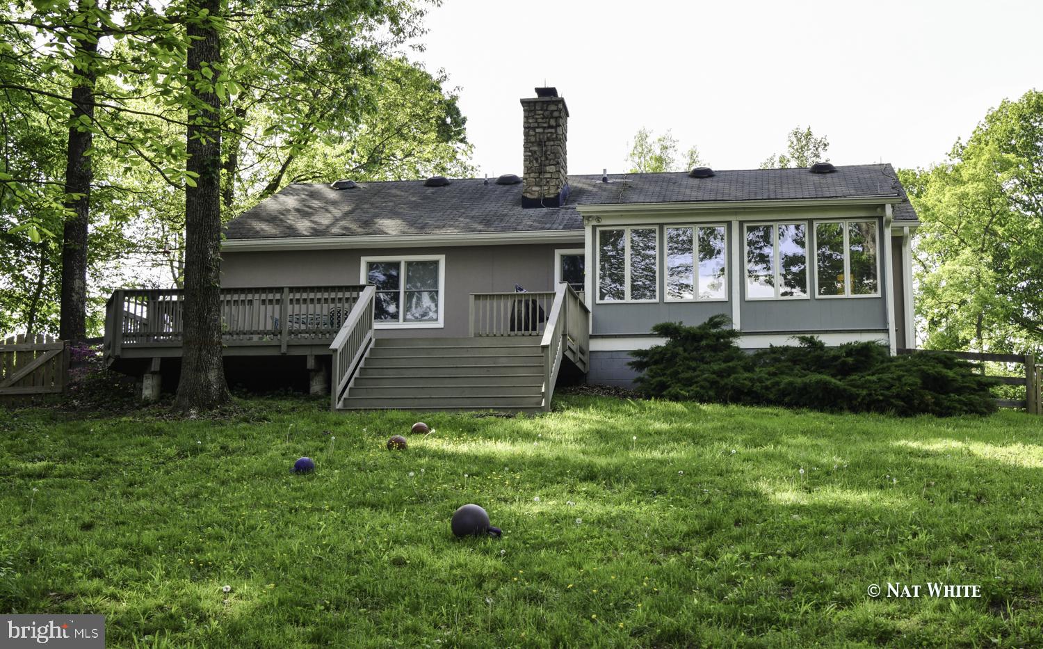 Rear sunroom opens to large multi-level deck