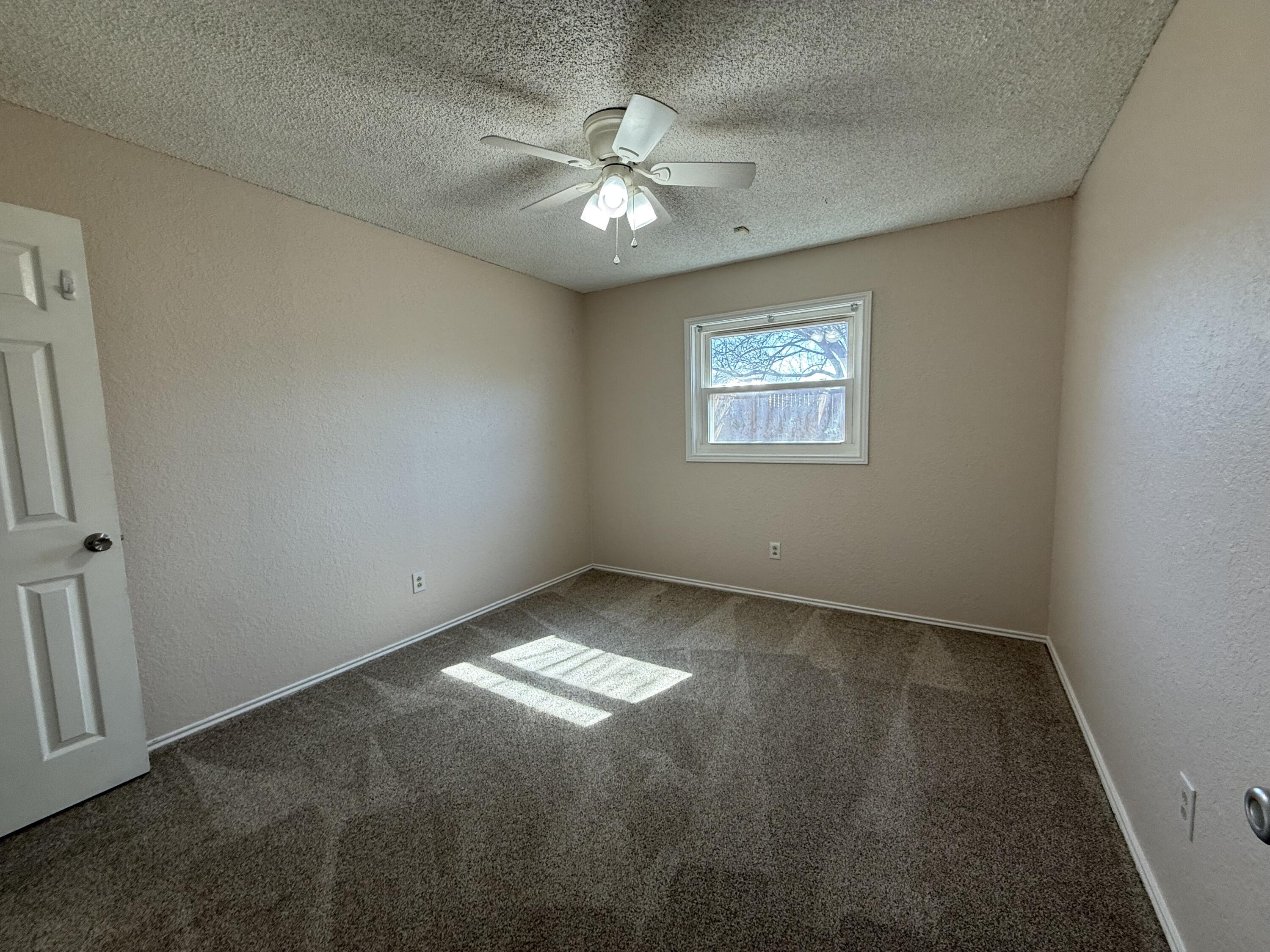 5729 89th Street Lubbock, TX 79424 - Photo 12 of 15 an empty room with windows and fan