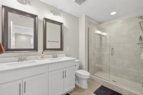 a bathroom with a double vanity sink mirror and toilet
