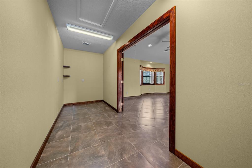5950 Southwest 21st Avenue Road Ocala, FL 34471 - Photo 20 of 79 a view of a hallway with wooden floor and a bathroom