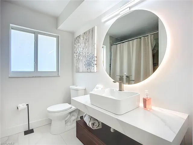a bathroom with a sink a toilet and mirror