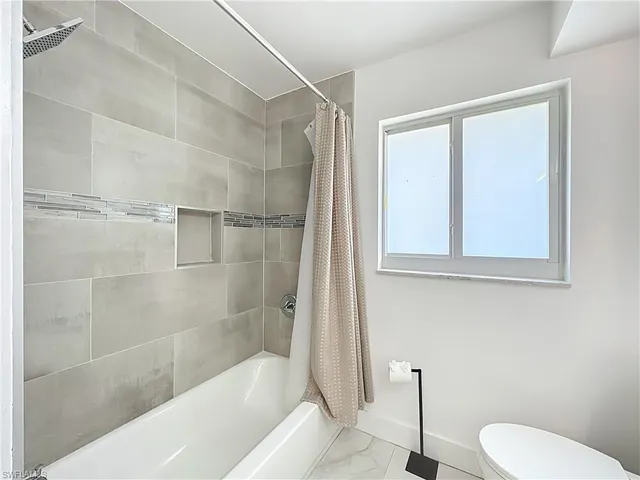 a bathroom with a shower a toilet and a sink