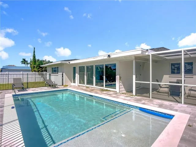 a view of a house with a swimming pool and sitting area