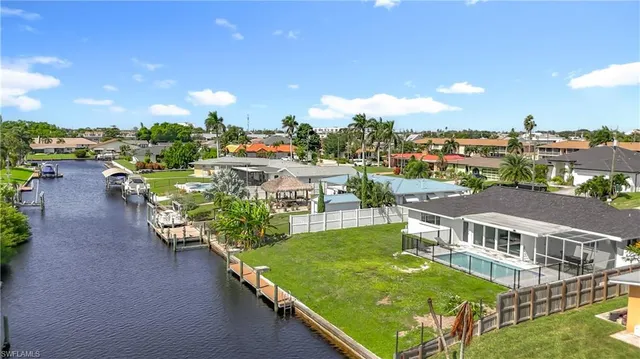an aerial view of a house with swimming pool a yard and outdoor seating