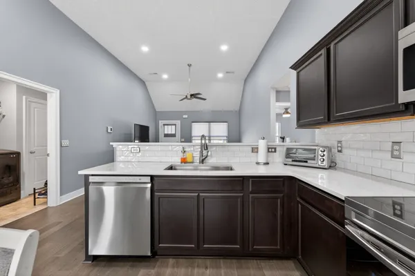 a kitchen with stainless steel appliances granite countertop a sink stove and cabinets