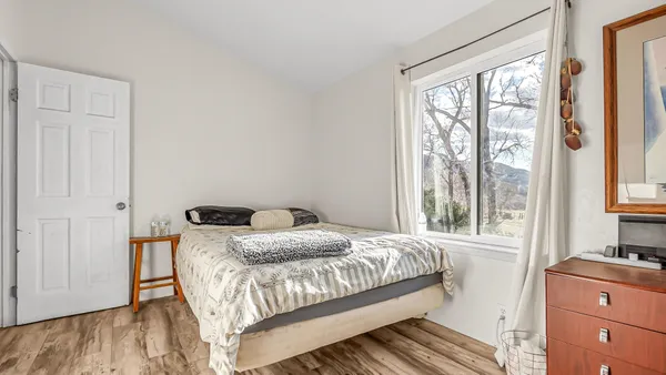 a bedroom with a bed and wooden floor