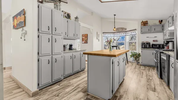 a kitchen with white cabinets and refrigerator