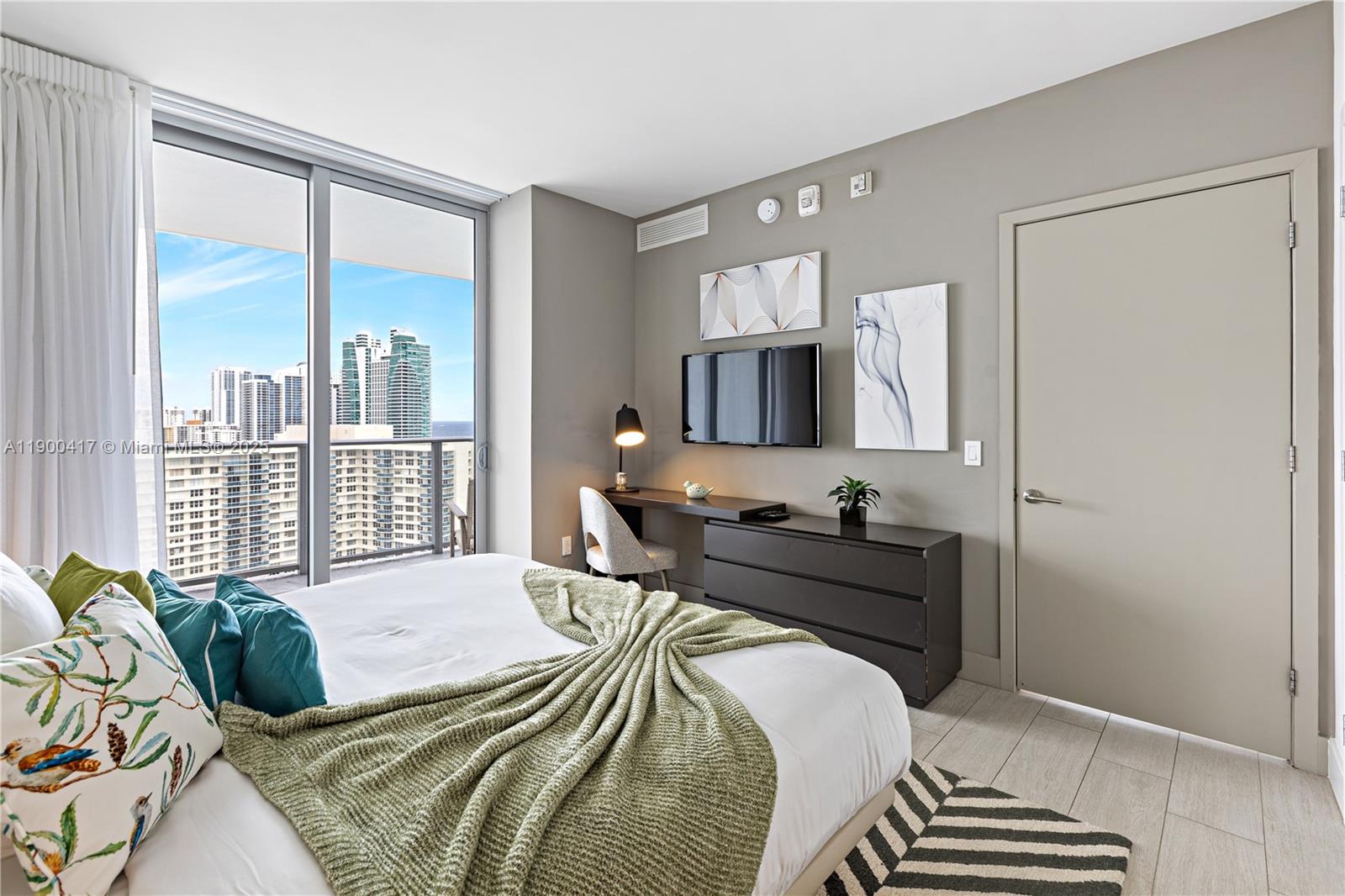 4010 South Ocean Drive, Unit R1701 Hollywood, FL 33019 - Photo 13 of 48 a bedroom with a bed and glass windows