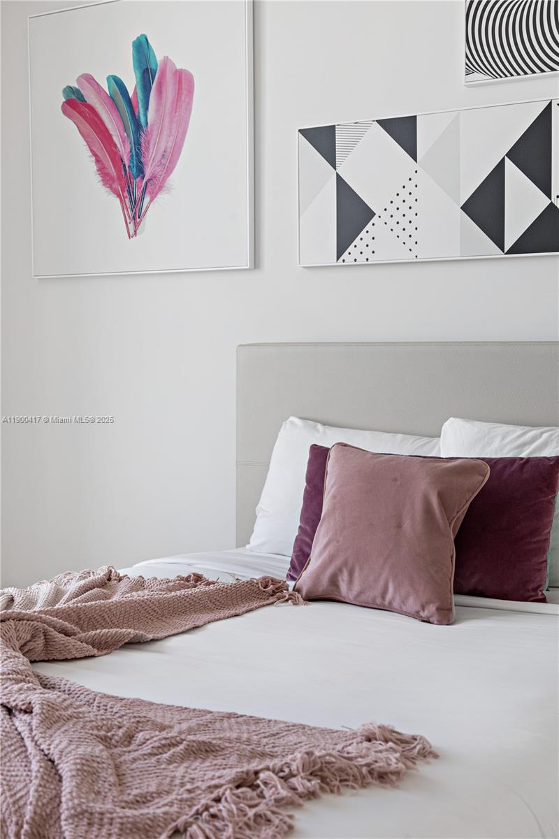 4010 South Ocean Drive, Unit R1701 Hollywood, FL 33019 - Photo 36 of 48 a bed with a white comforter and pillows