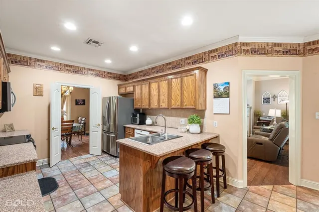 a open kitchen with stainless steel appliances kitchen island granite countertop a refrigerator and a stove top oven
