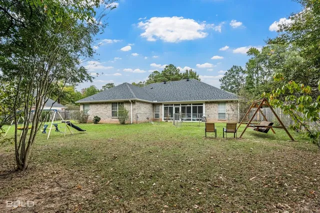 a view of a house with a yard and a tree