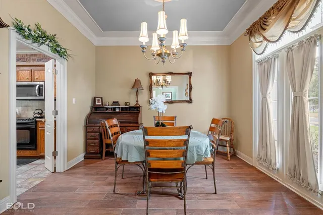 a dining room with furniture a chandelier and wooden floor