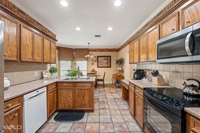 a kitchen with stainless steel appliances a stove sink microwave and cabinets