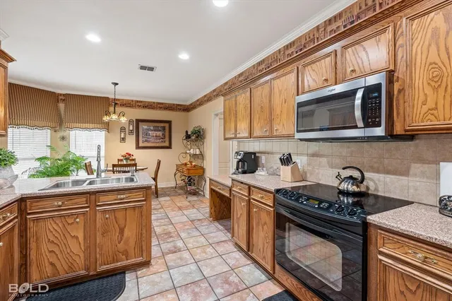 a kitchen with stainless steel appliances granite countertop a stove a sink and a microwave