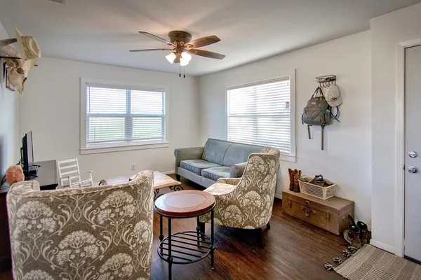 a living room with furniture and a ceiling fan